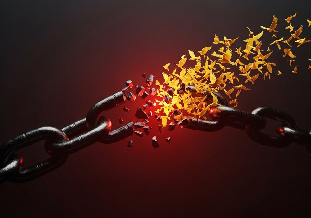 A breaking chain releasing golden birds, liberation and financial freedom
